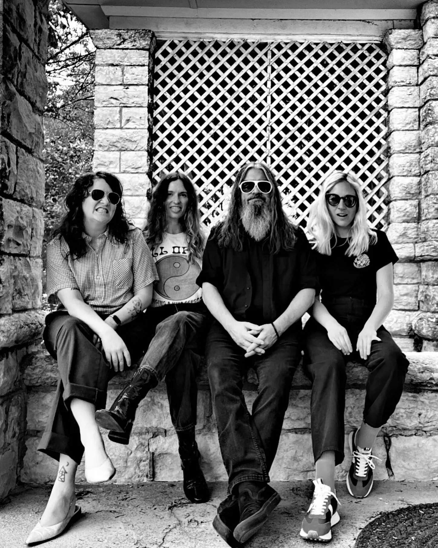 Black and white photo of band duchess sitting on a stone porch ledge.